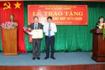 Đồng chí Bùi Quang Nhựt - Phó Bí thư Đảng ủy Khối các cơ quan tỉnh đã gắn Huy hiệu, trao Quyết định và tặng hoa chúc mừng cho đồng chí Ngô Văn Tổng